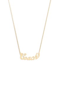 Gouden ketting met een "Coach" naamplaatje hanger in cursieve schrift, met kleine ster en strass accenten op een witte achtergrond.