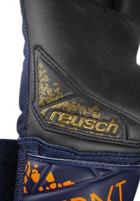 Guanto nero e blu con materiale testurizzato nero e logo "reusch" dorato, con dettagli a motivo geometrico nella zona del polso.