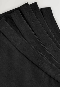 Schwarze Stoffleggings mit einer weichen Textur und breitem, elastischem Bund, der den eingeprägten Text "NEXT" und Herzmotive zeigt.