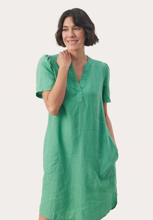 Vestido de lino verde con mangas cortas, escote en V y bolsillos laterales. Textura suave con un brillo sutil y corte relajado.