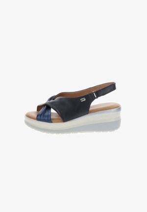 Sandalo a zeppa aperto blu navy con cinturini incrociati, cinturino posteriore regolabile, soletta imbottita color cuoio e suola bianca texturizzata.