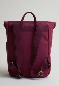 Bordeauxfärgad ryggsäck i strukturerad tyg, med rullöppning, justerbara remmar och sidofickor. Har detaljer i guldfärgad metall.