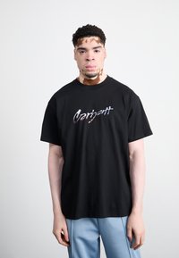Zwart katoenen t-shirt met kleurrijk "Carhartt" logo. Relaxed fit, korte mouwen, ronde hals. Zachte textuur en effen kleur.