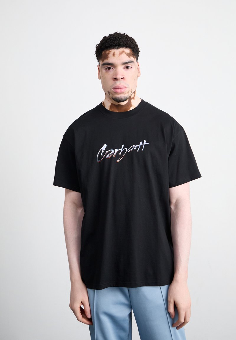 Zwart katoenen t-shirt met kleurrijk "Carhartt" logo. Relaxed fit, korte mouwen, ronde hals. Zachte textuur en effen kleur.