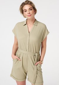 Lichtgroene, short-sleeve romper met kraag, knoopsluiting aan de voorkant, elastische taille en ceintuur. Heeft twee zijzakken en een gestructureerde stof.