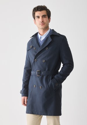 Marineblå trenchcoat med dobbeltknaplukning, bred krave, bælte i livet og sidelommer. Fremstillet af glat, mellemvægtigt stof.