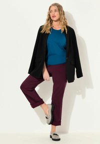 Türkisfarbenes Top, schwarzer Blazer, bordeauxrote Hosen mit umgeschlagenen Cuffs und graue Slipper mit einer Schleifenakzenten. Schlichtes Design und weiche Texturen.