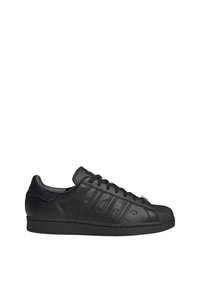 Le sneakers in pelle nera presentano una finitura liscia, dettagli in rilievo, tre strisce e un puntale testurizzato. Progettate con una silhouette a profilo basso.