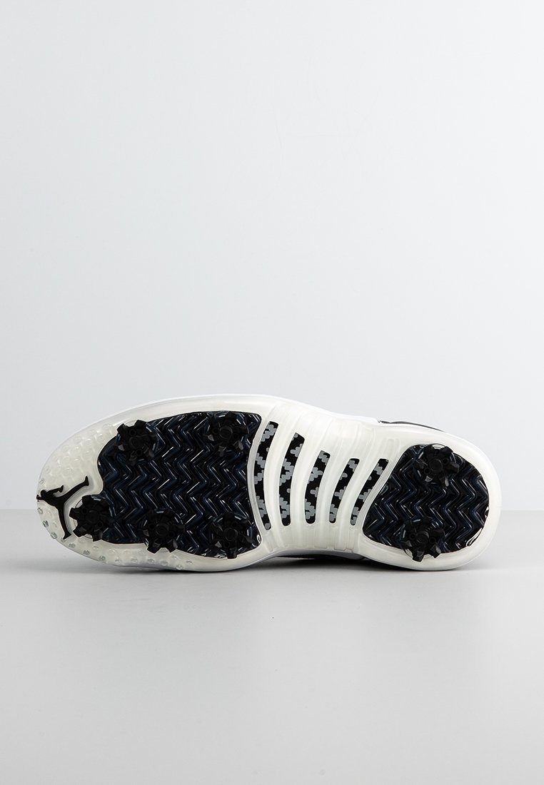 Biała i granatowa podeszwa sportowego obuwia z zygzakowatym wzorem, z czarnymi gumowymi wypustkami zapewniającymi przyczepność oraz gładką, teksturowaną powierzchnią.