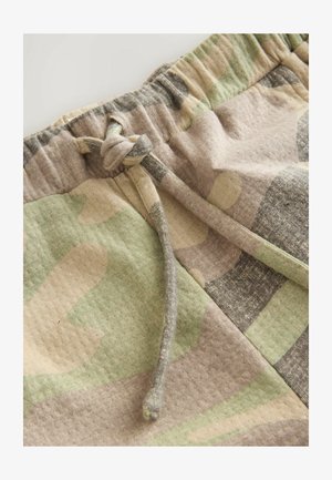 Camo-patterned shorts with a mix of green, beige, and gray hues. Features an elastic waistband and drawstring for adjustable fit.