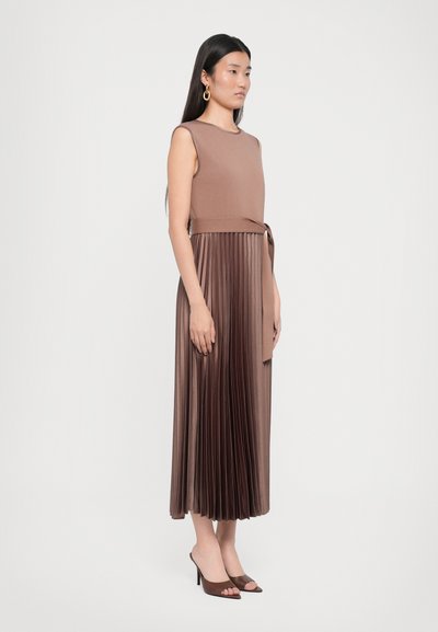 Sleeveless brown dress with a fitted top and pleated skirt, featuring a tied waist. Smooth texture and a below-knee length.