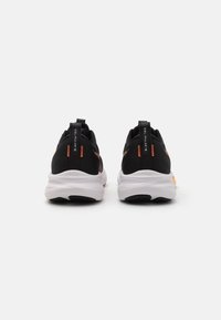 Black athletic sneakers with orange accents, mesh upper, cushioned white sole, and prominent heel grip. Features "GEL-PULSE" branding.