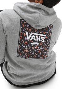 Sudadera gris con un diseño floral en la parte posterior y el logo de "VANS" en blanco. La tela parece suave y tiene un corte relajado.