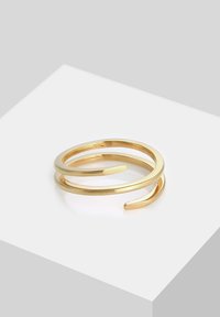 Kullatud metalles rõngas, millel on minimalistlik disain kahe põimunud detaili, siledapinnaline ja avatud otsadega.