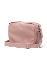 Bolsa de hombro rectangular en color rosa, hecha de tela suave. Cuenta con un cierre de cremallera, correa ajustable y una textura suave con detalles de diseño mínimos.