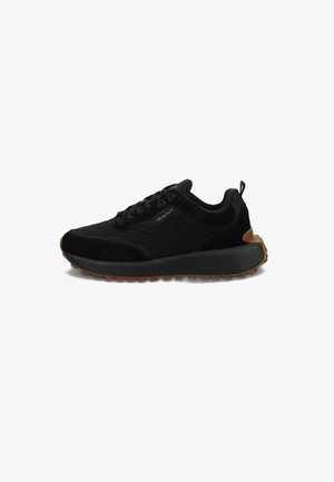 Black athletic shoes with a textured suede upper, rubber outsole, and a padded collar. Featuring a lace-up design and contrasting beige sole.