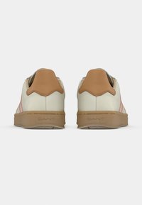 Άσπρα αθλητικά παπούτσια με ταμπ επιφάνειας σε χρώμα ταμπά, με δύο ροζ ρίγες, υφασμένο καουτσούκ σόλα και ανάγλυφο λογότυπο στο πίσω μέρος.