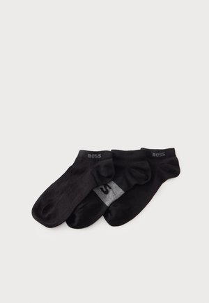 Trois chaussettes noires courtes avec des logos BOSS gris, qui se chevauchent sur un fond clair.