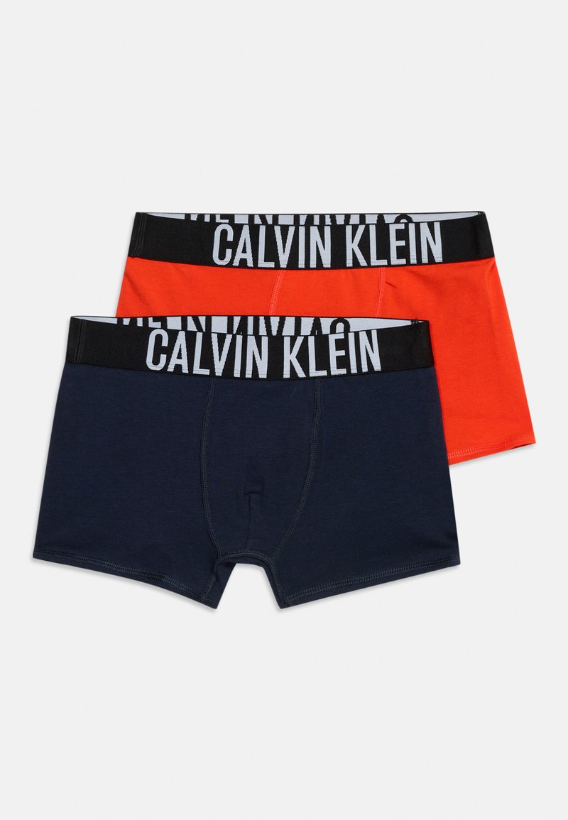 Δύο ζευγάρια ανδρικά boxer briefs, ένα σε ναυτικό μπλε και ένα σε πορτοκαλί, με μαύρες ζώνες μέσης με λευκή επιγραφή "Calvin Klein".