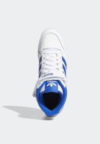 Tenisky s vysokým střihem, bílý kožený svršek, modré pruhované detaily, perforované prvky na špičce a polstrovaný límec. Bílé tkaničky.