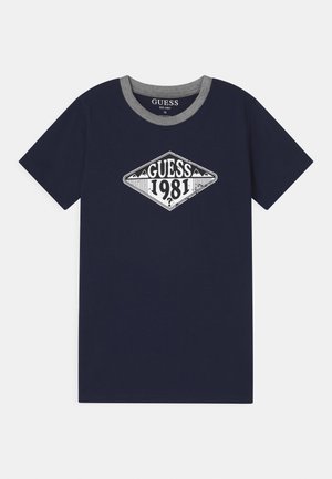Granatowy t-shirt z krótkim rękawem, szarym kołnierzykiem i białym, diamentowym logo „GUESS 1981” na środku z przodu.