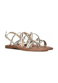 Metalen gouden platte sandalen hebben meerdere kruisslagen en een bruine platte zool. Verstelbare enkelriem met gespsluiting.