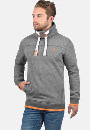Gray pullover hoodie with a high collar, white drawstrings, and orange accents at the hem. Features a front pocket and textured fabric.