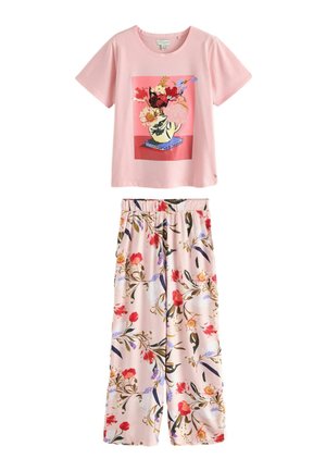 Pinkes kurzärmeliges Top mit floralem Vasenprint, kombiniert mit weit geschnittenen Hosen mit mehrfarbigem Blumenmuster auf hellem rosa Hintergrund.