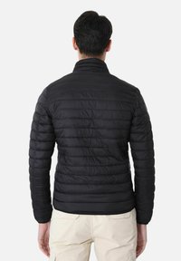 Giacca a vento nera con un design trapuntato, colletto alto e maniche lunghe. Materiale morbido e leggero, aderente in vita.