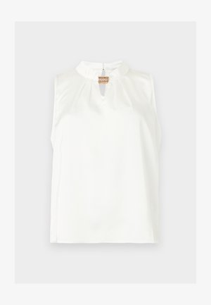 Blouse blanche sans manches avec col montant et petite ouverture devant, fermée par une seule agrafe décorative dorée.