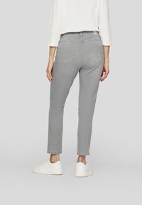 Gray denim jeans with five-pocket design, straight legs, and visible stitching detail. Worn with white sneakers.