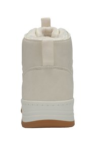 Cream-colored synthetic ankle boot with faux fur lining, flat white sole, and tan rubber outsole; features a back pull tab for easy wear.