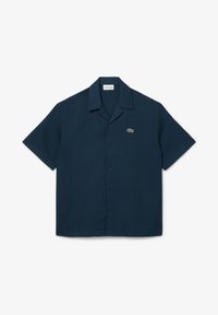 Ναυτικό κοντομάνικο πουκάμισο με υφασμάτινη υφή, δύο κουμπιά και ένα μικρό πράσινο λογότυπο κροκόδειλου στο αριστερό στήθος. Σχεδίαση με γιακά.