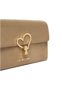 Beige keinonahkainen käsilaukku, jossa on kultainen sydämenmuotoinen lukko ja pohjassa kohokuvioitu "LOVE MOSCHINO" -brändäys. Sileä pinta ja läpällinen muotoilu.