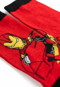 Calze rosse con un polsino nero e un design grafico di un personaggio giallo e nero sulla parte anteriore. Morbido tessuto a maglia.