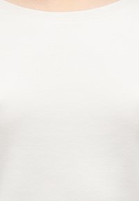 Witte geribbelde tanktop met een ronde hals en een naadloos ontwerp, gemaakt van een zachte, lichtgewicht stof met een gladde textuur.