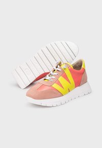 Zapatillas con una parte superior en tonos rosa y naranja, con acentos amarillos, suela blanca y superficie texturizada. Incluyen cordones y detalles de la marca.