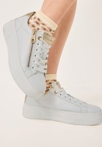 Sneakers in pelle blu chiaro con suola bianca texturizzata, dotati di cerniera laterale, dettagli con lacci e accessori in tonalità oro.