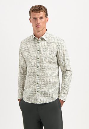 Long-sleeve button-up shirt in light green, featuring a small abstract print, pointed collar, and front pocket, made from a soft fabric.