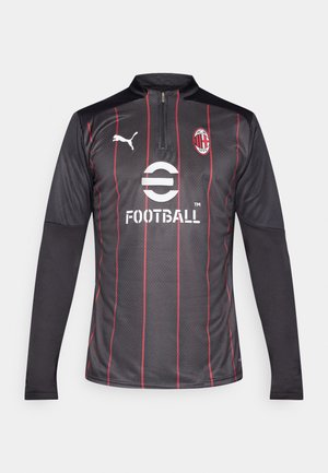 Čierny futbalový dres s dlhým rukávom a červenými vertikálnymi pruhmi, s polovovým zipsom, akcentmi loga a textúrovaným dizajnom látky.