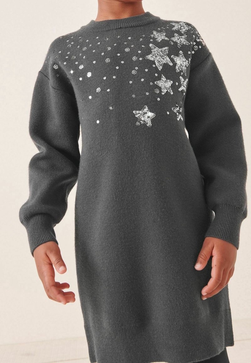 Robe-pull grise à manches longues, ornée de sequins étoiles argentés et au tricot texturé. Poignets et ourlet côtelés pour plus de structure.
