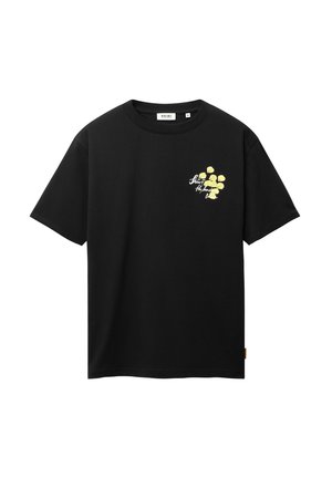 Camiseta negra de manga corta con un pequeño gráfico floral amarillo y texto blanco en cursiva en el lado izquierdo del pecho.