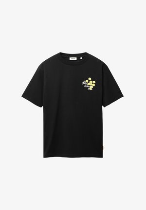 Camiseta negra de manga corta con un pequeño gráfico floral amarillo y texto blanco en cursiva en el lado izquierdo del pecho.