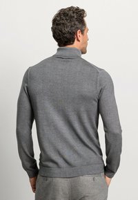 Grauer Pullover mit hohem Kragen, langen Ärmeln und glatter Textur. Verfügt über dezente Muster und gerippte Akzente am Saum und den Bündchen.
