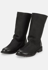 Par de botas negras de cuero hasta la mitad de la pantorrilla con punteras redondeadas, suelas planas y textura ligeramente arrugada, mostradas en ángulo para ver vistas frontal y lateral.