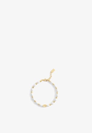 Pulsera en tono dorado que presenta cuentas ovaladas blancas alternas y separadores dorados, con un cierre de langosta y una cadena de extensión corta.