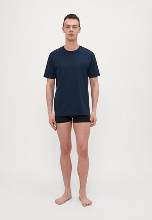 Marineblauwe kortekhuismouw t-shirt van gladde stof, gecombineerd met zwarte aansluitende shorts. Eenvoudig ontwerp, geen zichtbare patronen of logo's.