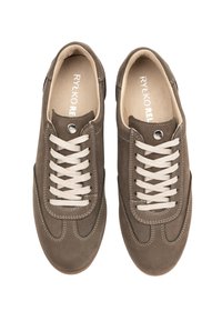 Brązowe zamszowe trampki z białymi sznurowadłami, z zaokrąglonym noskiem i kontrastowym przeszyciem. Gładka wewnętrzna wyściółka, logo na wkładce.