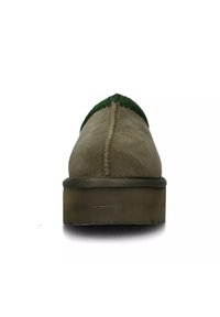 Scarpa verde in camoscio con punta arrotondata, presenta una parte superiore texturizzata, cucitura centrale e una suola platform spessa di colore chiaro.
