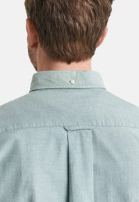 Lichtblauw chambray overhemd, met een button-down kraag, een rugplooi en subtiele textuur. Geschikt gesneden met minimale hardware.